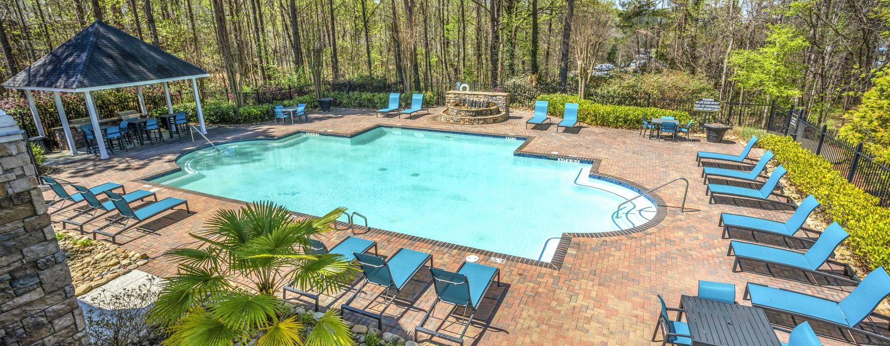 a swimming pool with chairs and a covered patio