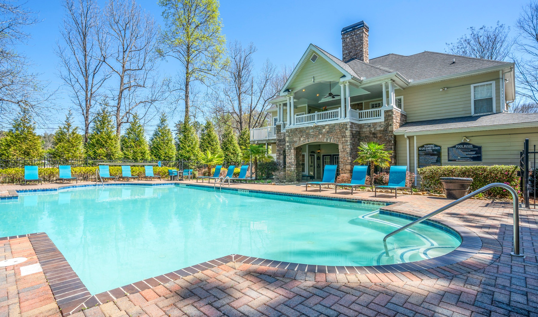 Large pool with shaded seating and clubhouse access.